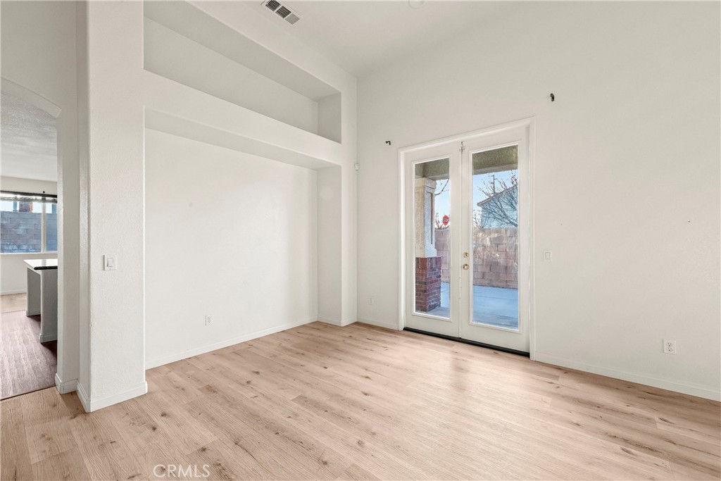 4660 Spice Street Lancaster, CA 93536 - Photo 12 of 42 an empty room with wooden floor and windows