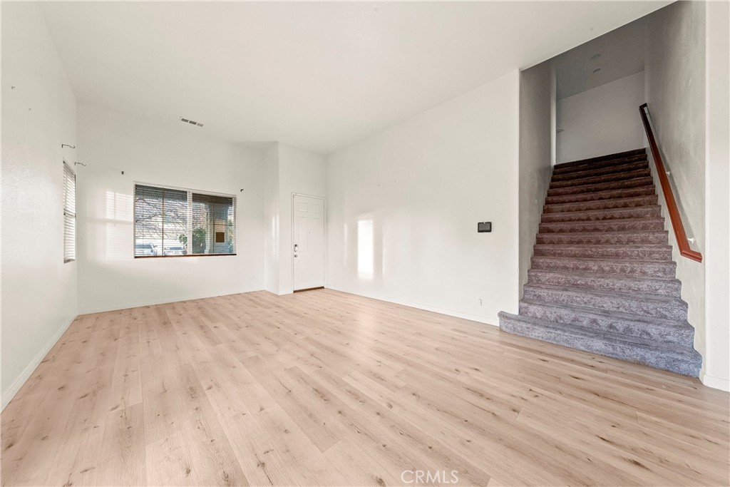 4660 Spice Street Lancaster, CA 93536 - Photo 13 of 42 a view of an empty room with wooden floor and stairs