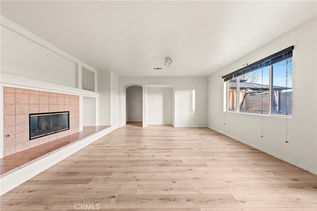 4660 Spice Street Lancaster, CA 93536 - Photo 14 of 42 a view of an empty room with a fireplace and a window