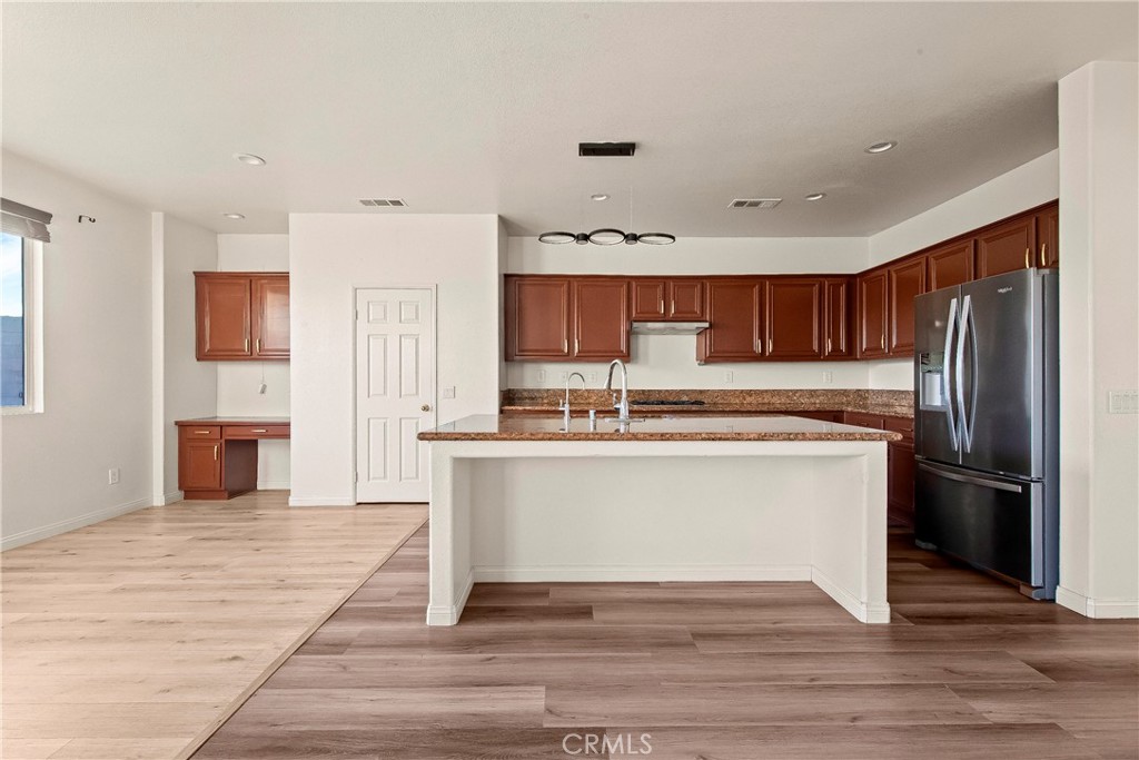 4660 Spice Street Lancaster, CA 93536 - Photo 18 of 42 a kitchen with stainless steel appliances granite countertop a refrigerator and a stove top oven