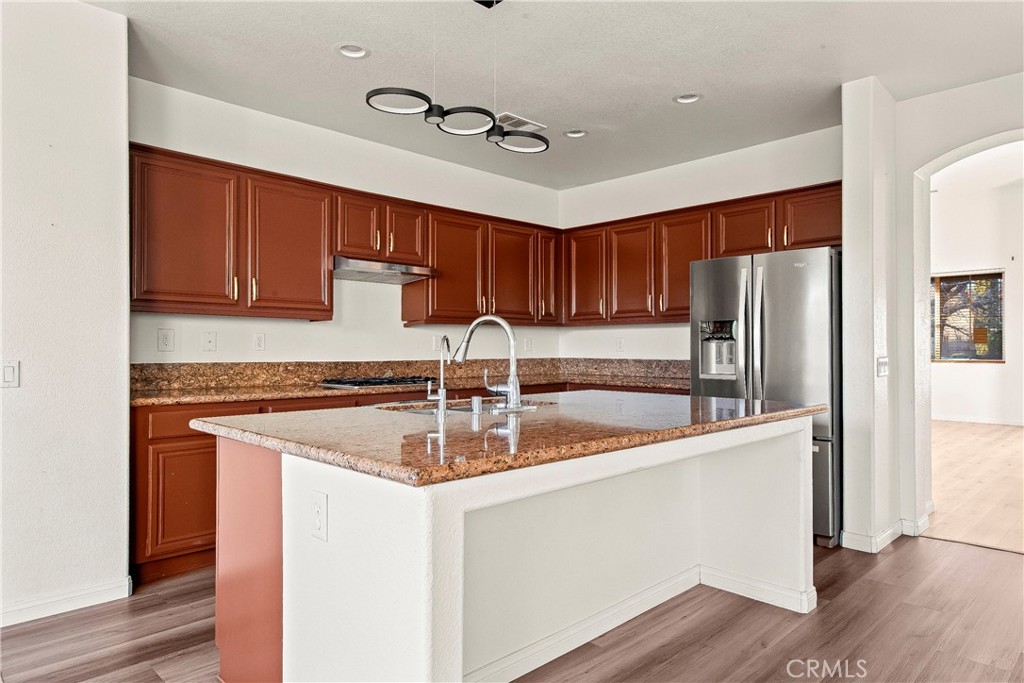 4660 Spice Street Lancaster, CA 93536 - Photo 19 of 42 a kitchen with stainless steel appliances granite countertop a sink stove and refrigerator