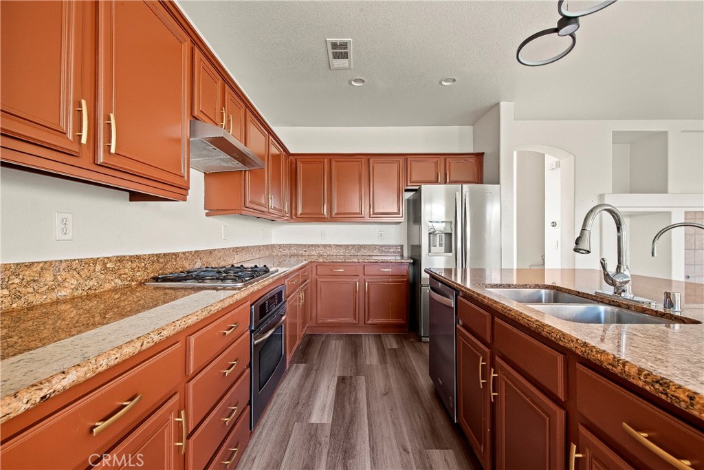 4660 Spice Street Lancaster, CA 93536 - Photo 21 of 42 a kitchen with granite countertop a sink a counter space stainless steel appliances and cabinets