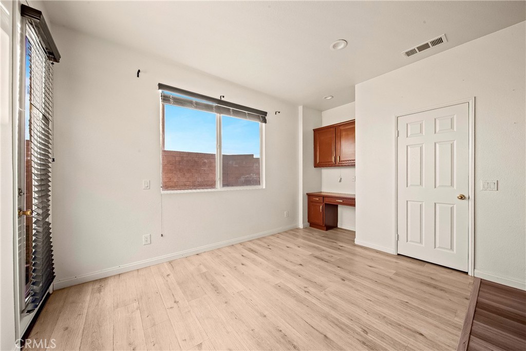 4660 Spice Street Lancaster, CA 93536 - Photo 22 of 42 an empty room with wooden floor cabinet and windows