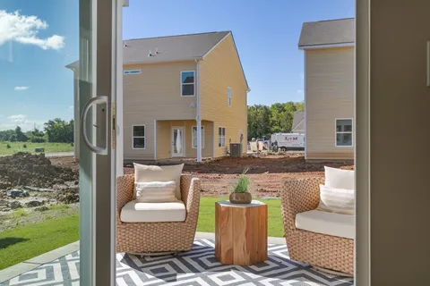 a backyard of a house with lawn chairs and a yard