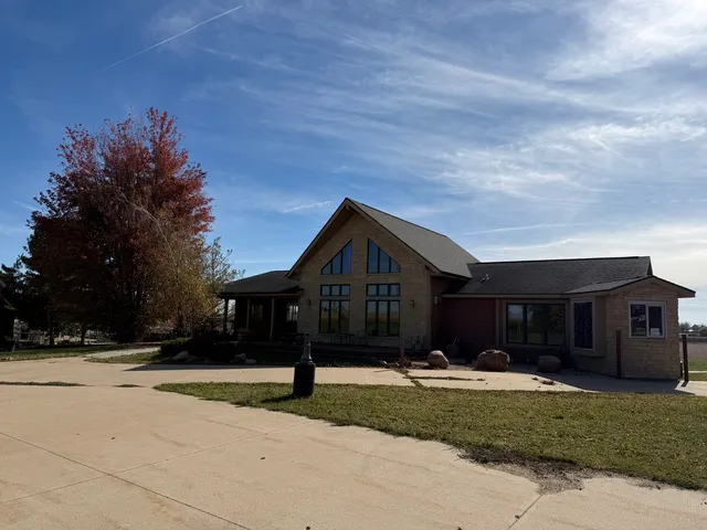a front view of house with yard and trees in the background