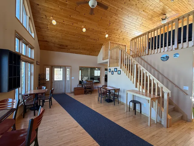a living room with stainless steel appliances furniture and a flat screen tv