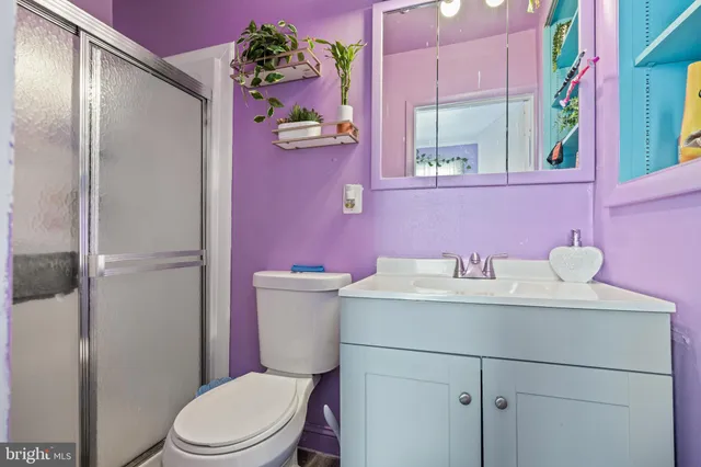 a bathroom with a sink vanity mirror and toilet