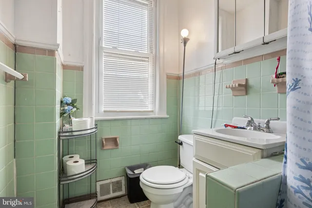 a bathroom with a granite countertop toilet sink and mirror