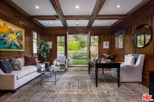 a dining room with wooden floor a chandelier a glass table and chairs
