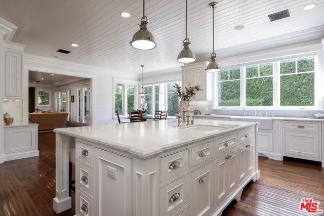a kitchen with white cabinets and sink