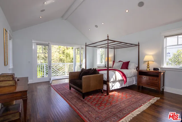 a living room with furniture large window and wooden floor