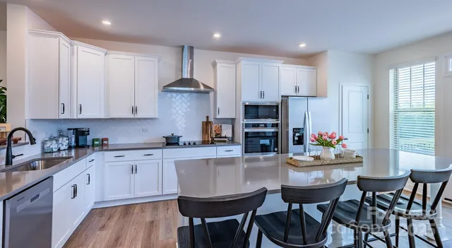 a kitchen with kitchen island granite countertop a sink and white cabinets