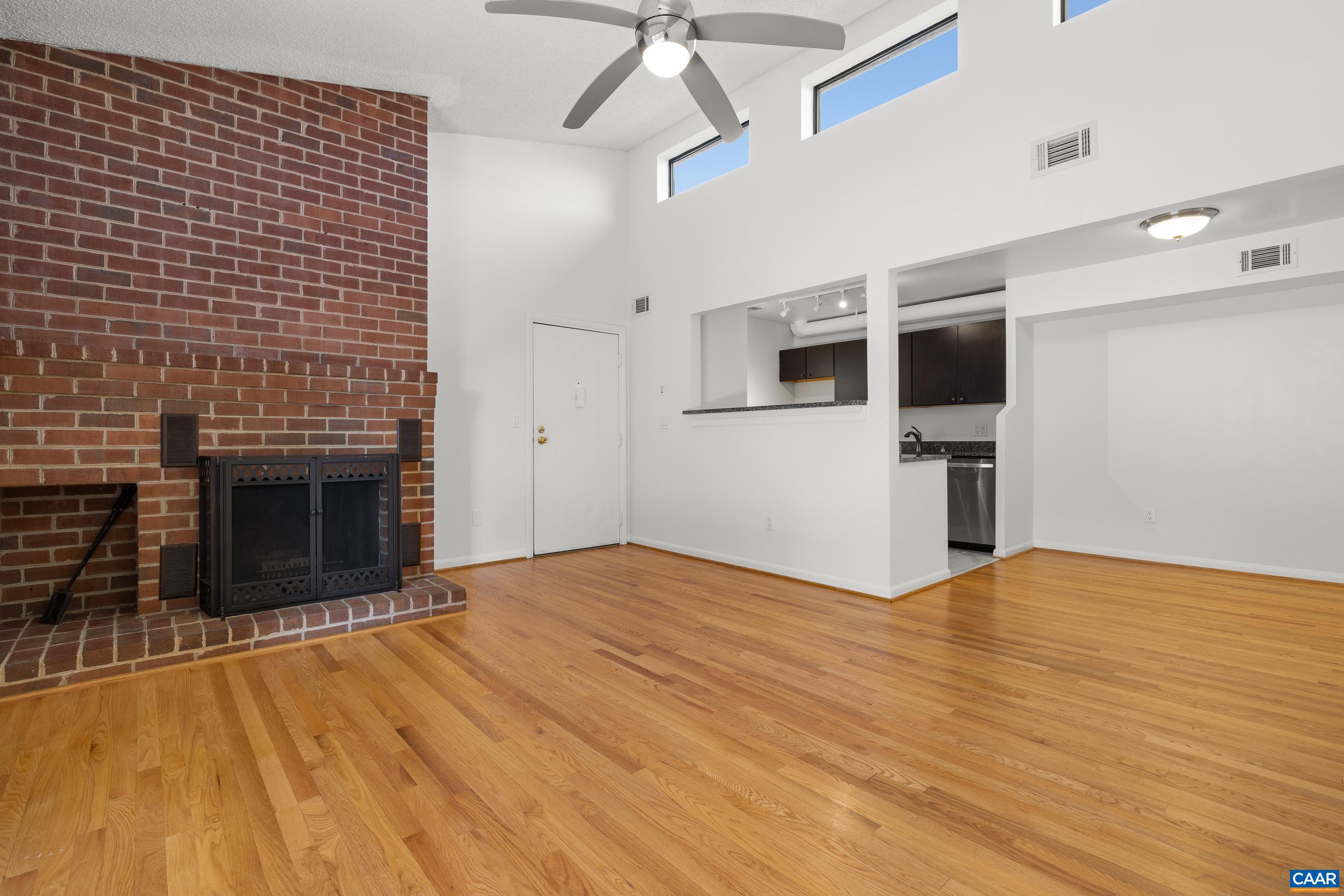 a view of empty room with a fireplace and wooden floor