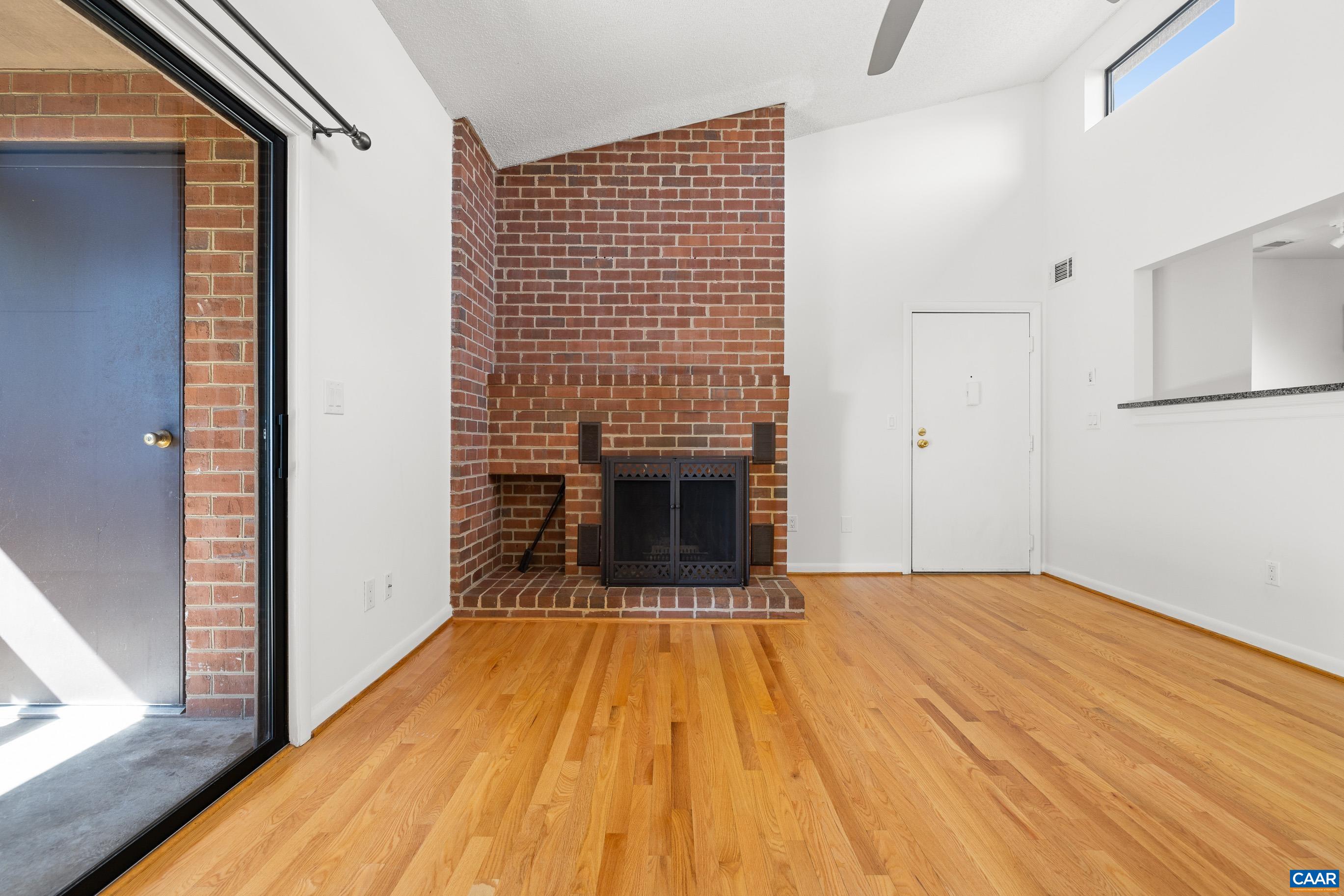 127 Turtle Creek Road, Unit 12 Charlottesville, VA 22901 - Photo 4 of 33 a view of a livingroom with wooden floor and a fireplace
