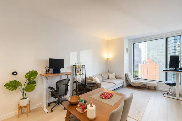 a living room with furniture a flat screen tv and a large window
