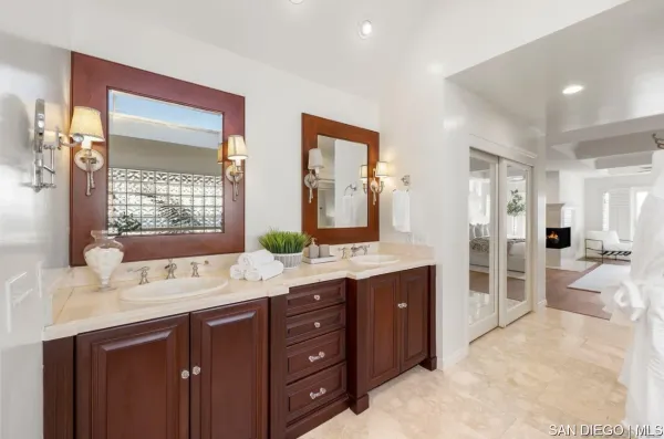 a spacious bathroom with a double vanity sink a large mirror and a shower