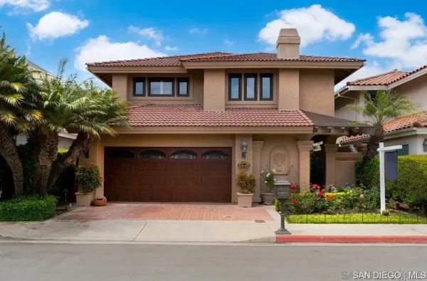 a front view of a house with a garden and plants