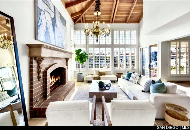 a living room with furniture a fireplace and a floor to ceiling window