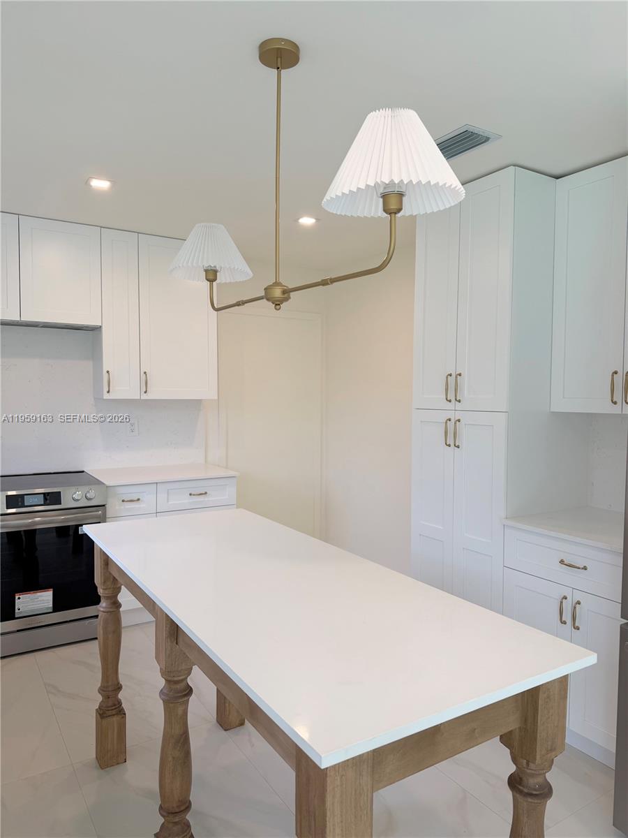 19221 Southwest 92nd Road Cutler Bay, FL 33157 - Photo 10 of 30 a kitchen with a appliances a stove a table and chairs