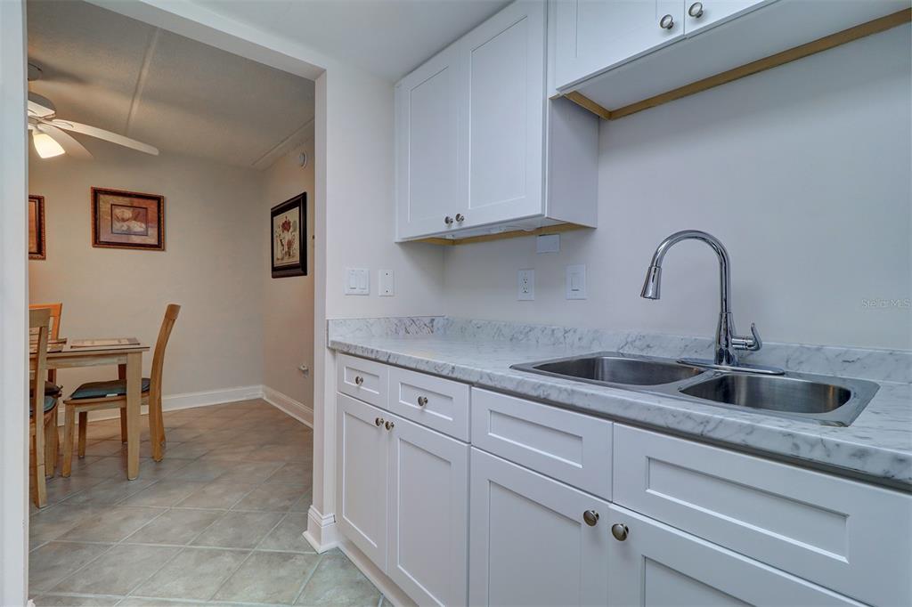 12760 Indian Rocks Road, Unit 1004 Largo, FL 33774 - Photo 16 of 45 a kitchen with granite countertop a sink and cabinets