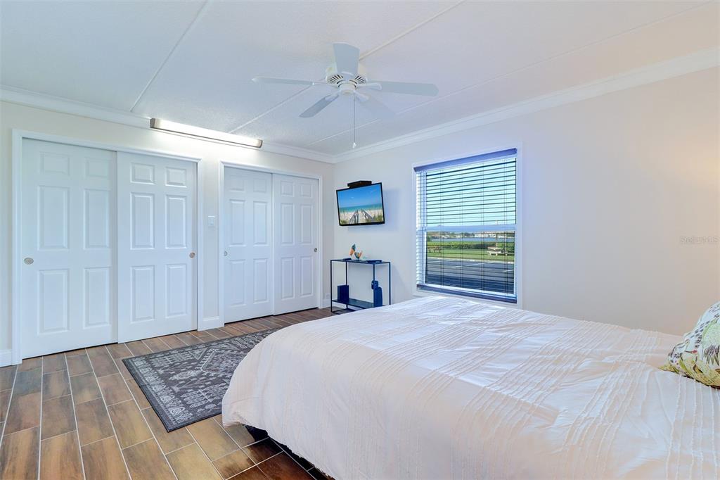 12760 Indian Rocks Road, Unit 1004 Largo, FL 33774 - Photo 18 of 45 a bedroom with a large bed and a chandelier
