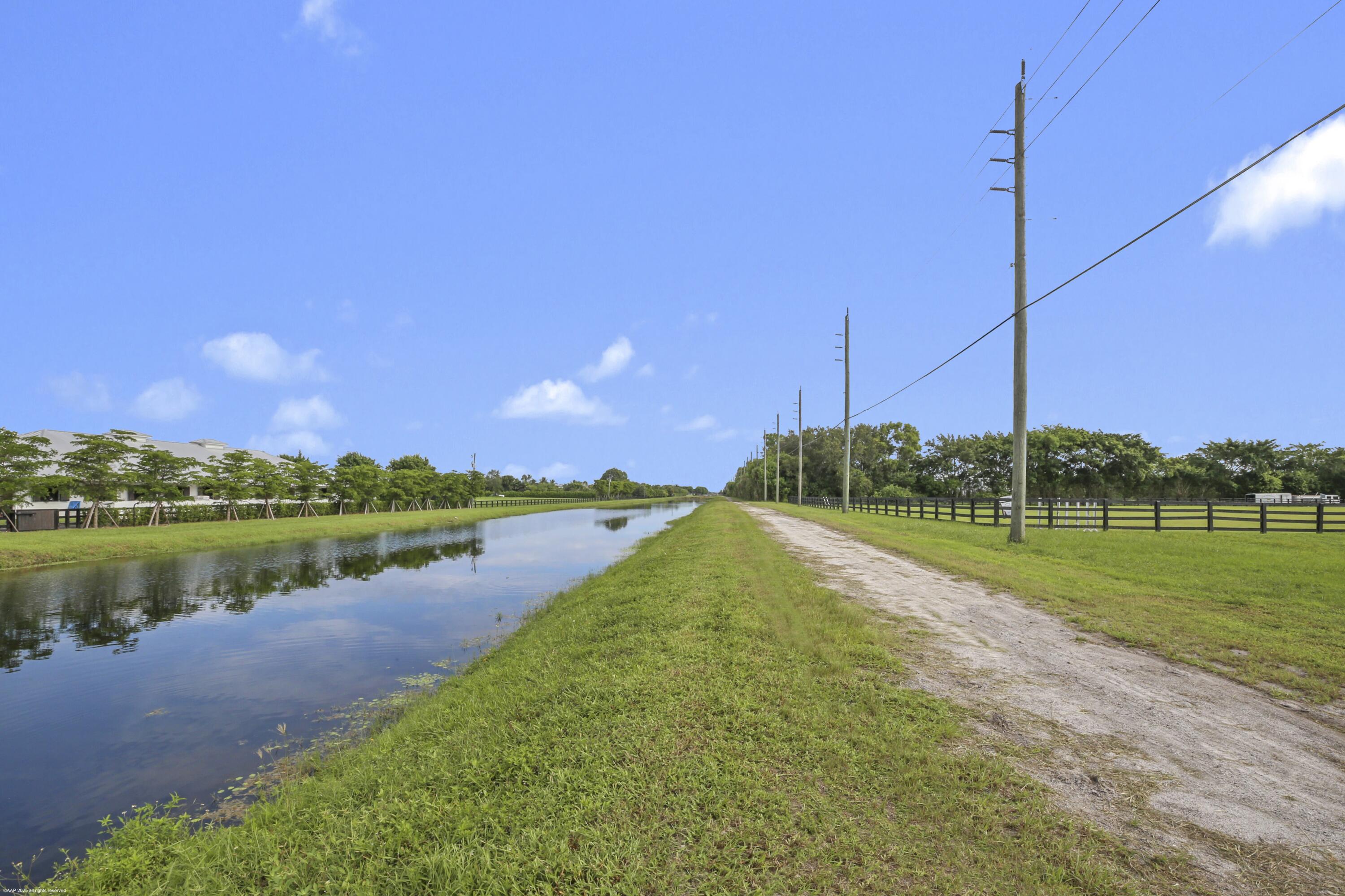 3899 Shutterfly Way Wellington, FL 33414 - Photo 16 of 27 a view of a lake with a big yard