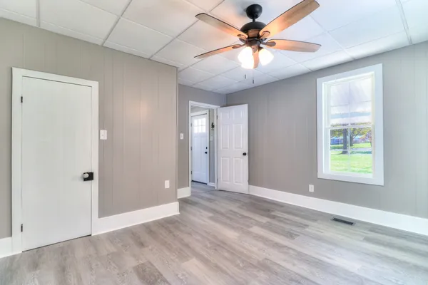 an empty room with fan and windows