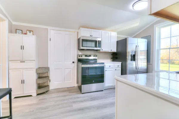 a kitchen with granite countertop a refrigerator and a stove top oven