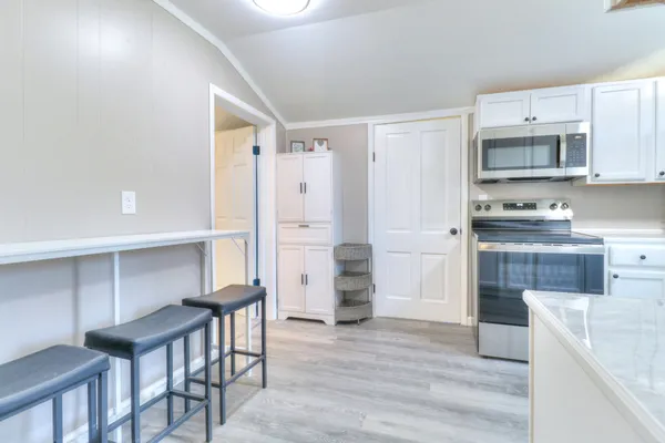 a kitchen with stainless steel appliances cabinets and a wooden floor