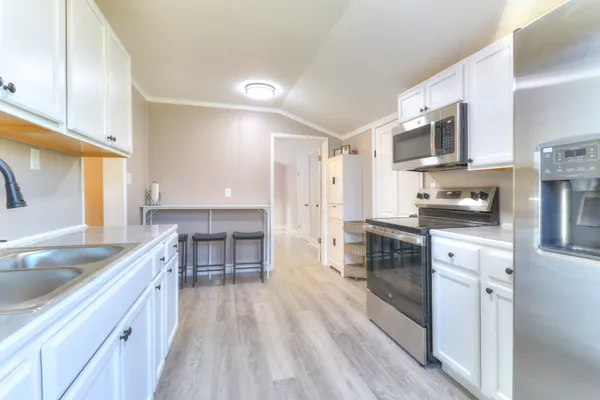 a kitchen with stainless steel appliances granite countertop a sink stove and refrigerator
