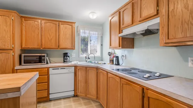 a kitchen with stainless steel appliances granite countertop a sink stove and cabinets