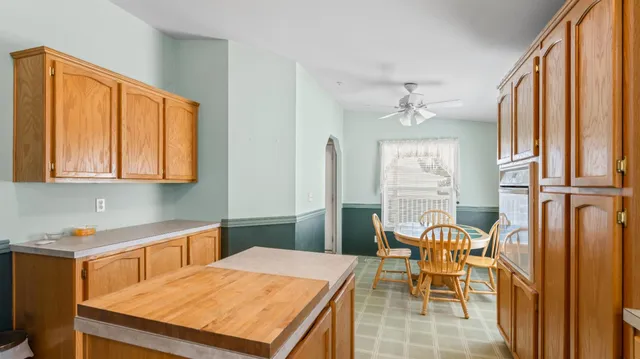 a kitchen with a table chairs and windows