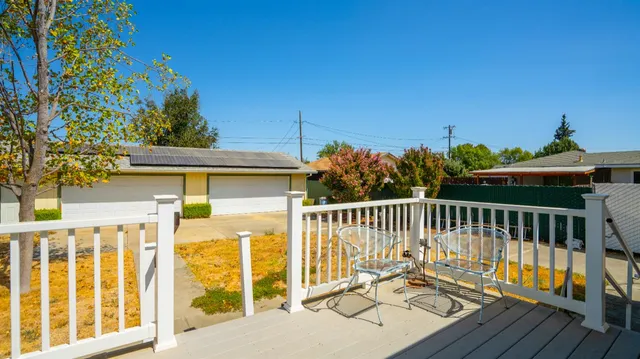 a view of a chair and table on the wooden deck