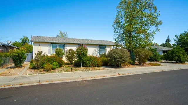 a front view of a house with a yard and potted plants