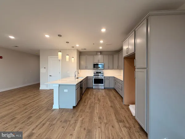 a kitchen with stainless steel appliances granite countertop a refrigerator and a stove top oven