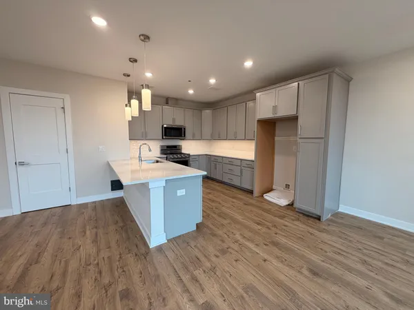 a view of kitchen with kitchen island wooden floor and center island