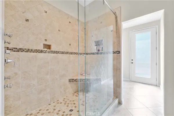 a large white kitchen with a large center island and some chairs