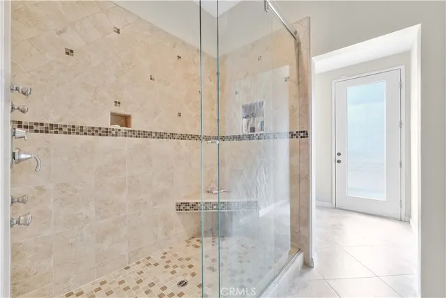 a large white kitchen with a large center island and some chairs