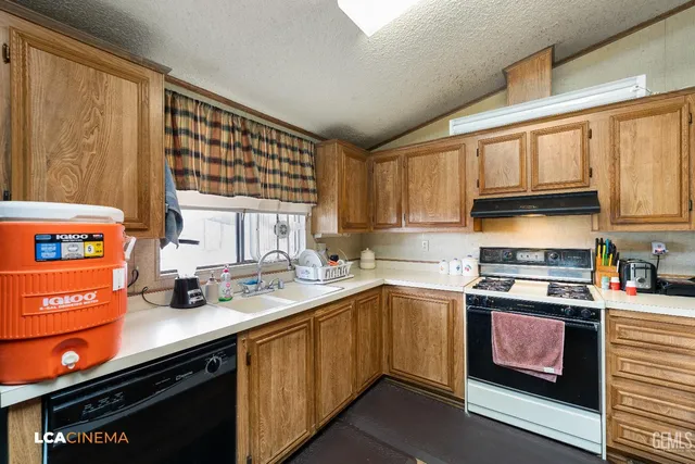 a kitchen with stainless steel appliances a sink stove and cabinets