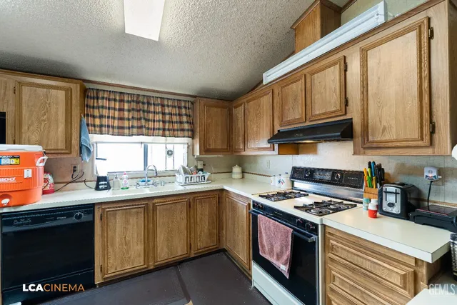a kitchen with stainless steel appliances granite countertop a sink stove and cabinets