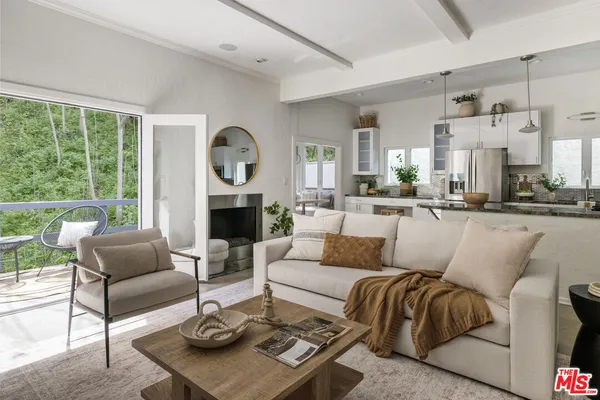 a living room with furniture a large window and a fireplace