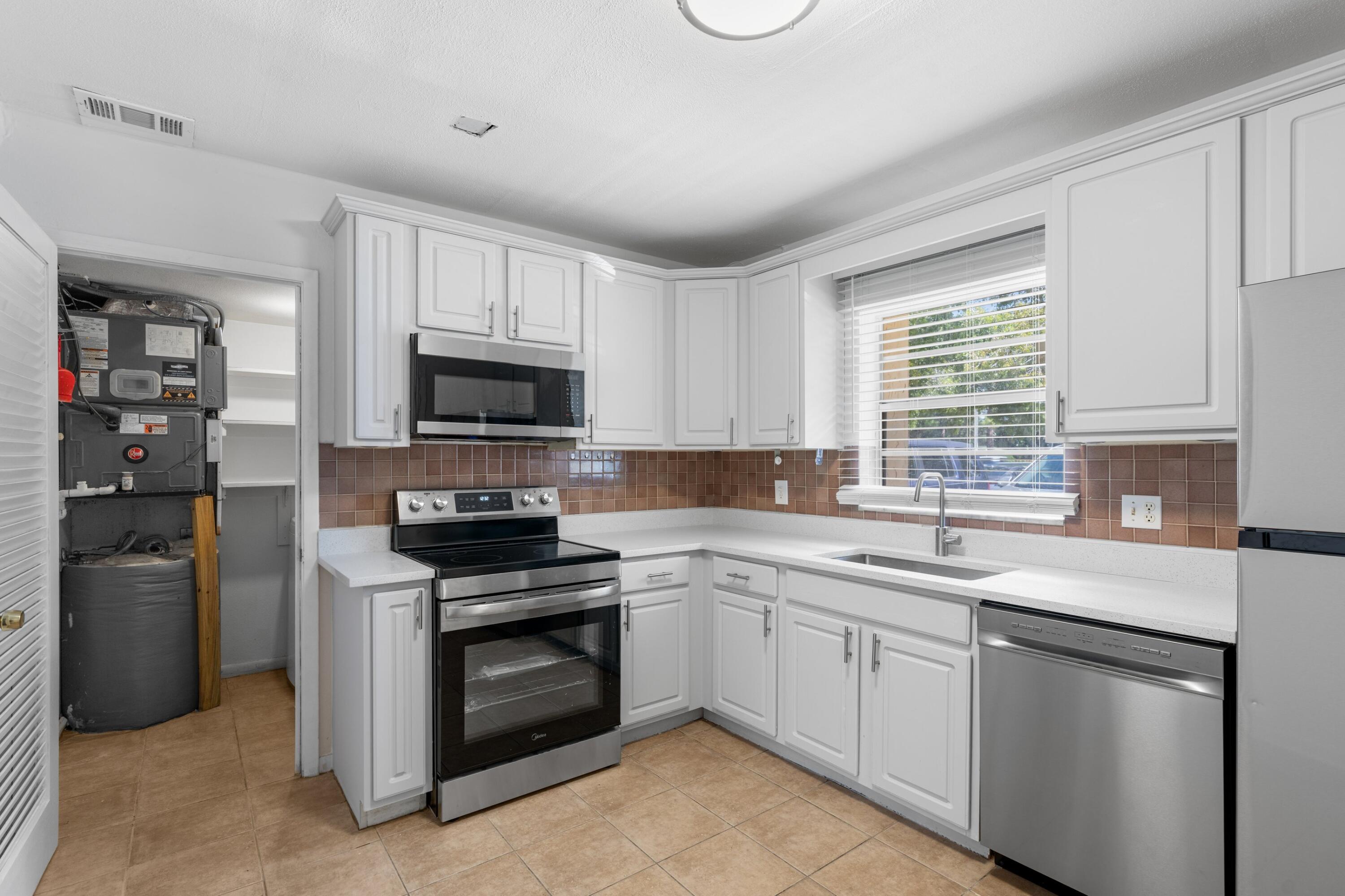 10693 North Military Trail, Unit 7 Palm Beach Gardens, FL 33410 - Photo 12 of 28 a kitchen with a sink stove and microwave