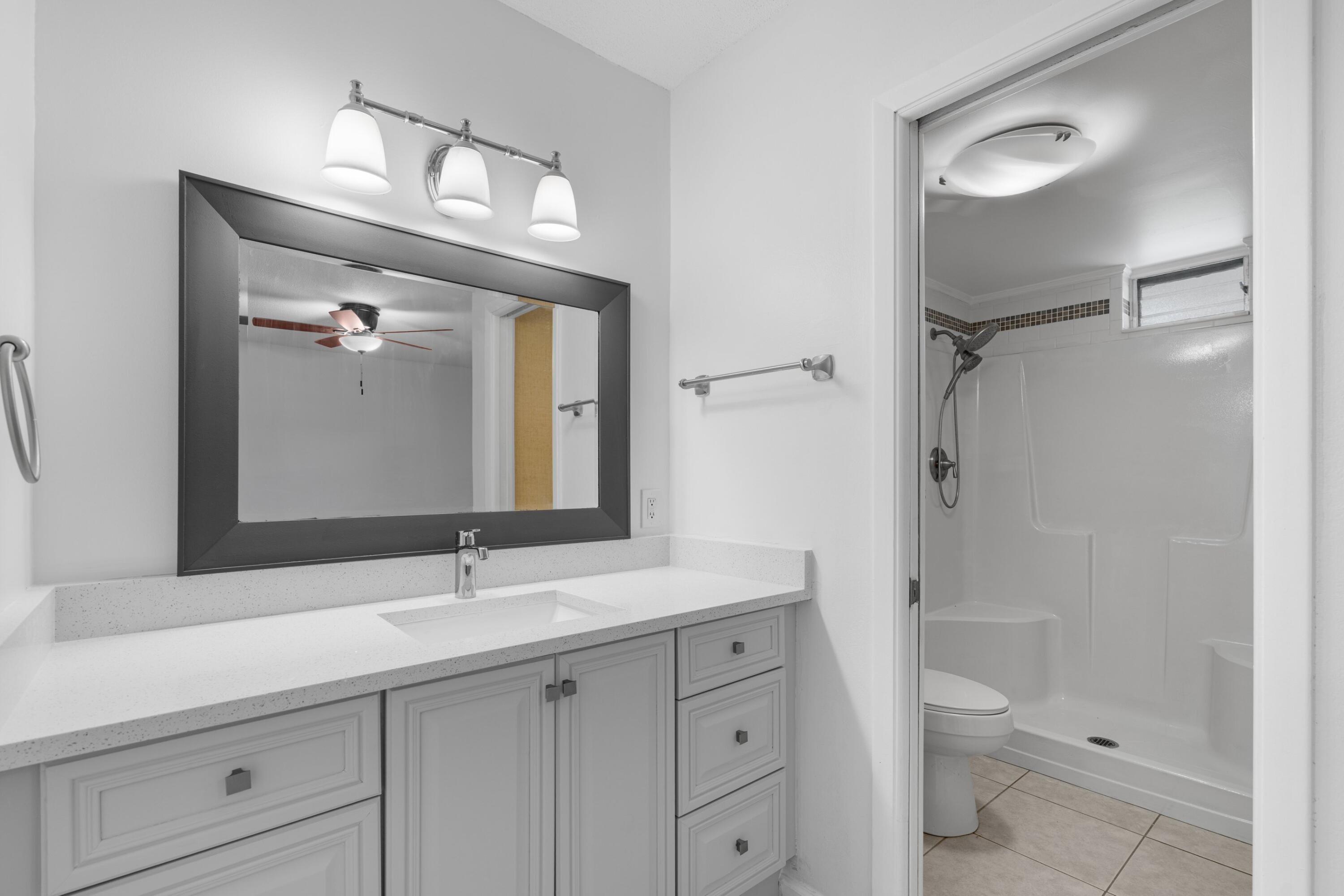 10693 North Military Trail, Unit 7 Palm Beach Gardens, FL 33410 - Photo 15 of 28 a bathroom with a sink a toilet and a mirror