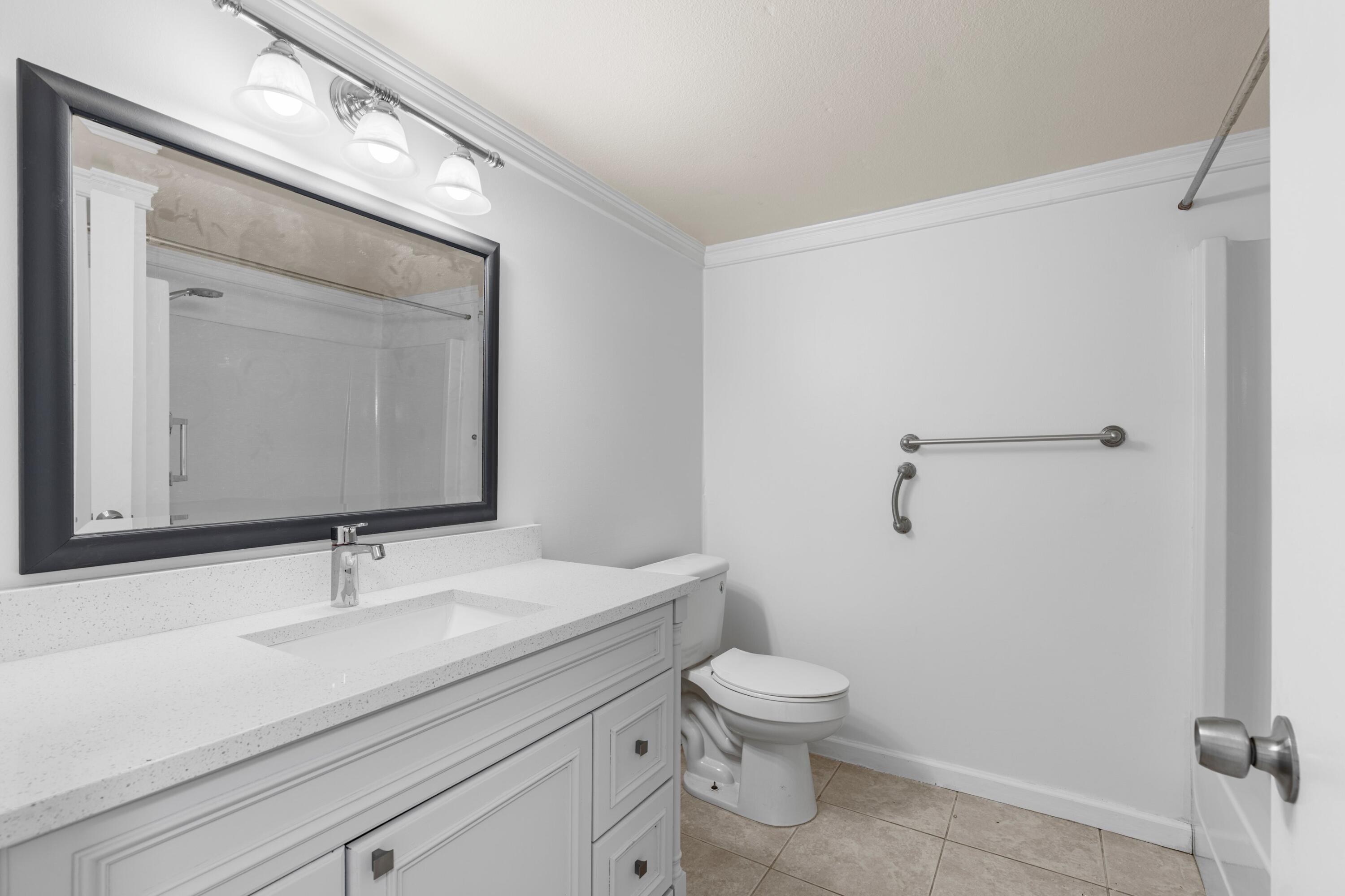 10693 North Military Trail, Unit 7 Palm Beach Gardens, FL 33410 - Photo 16 of 28 a bathroom with a toilet a sink and mirror