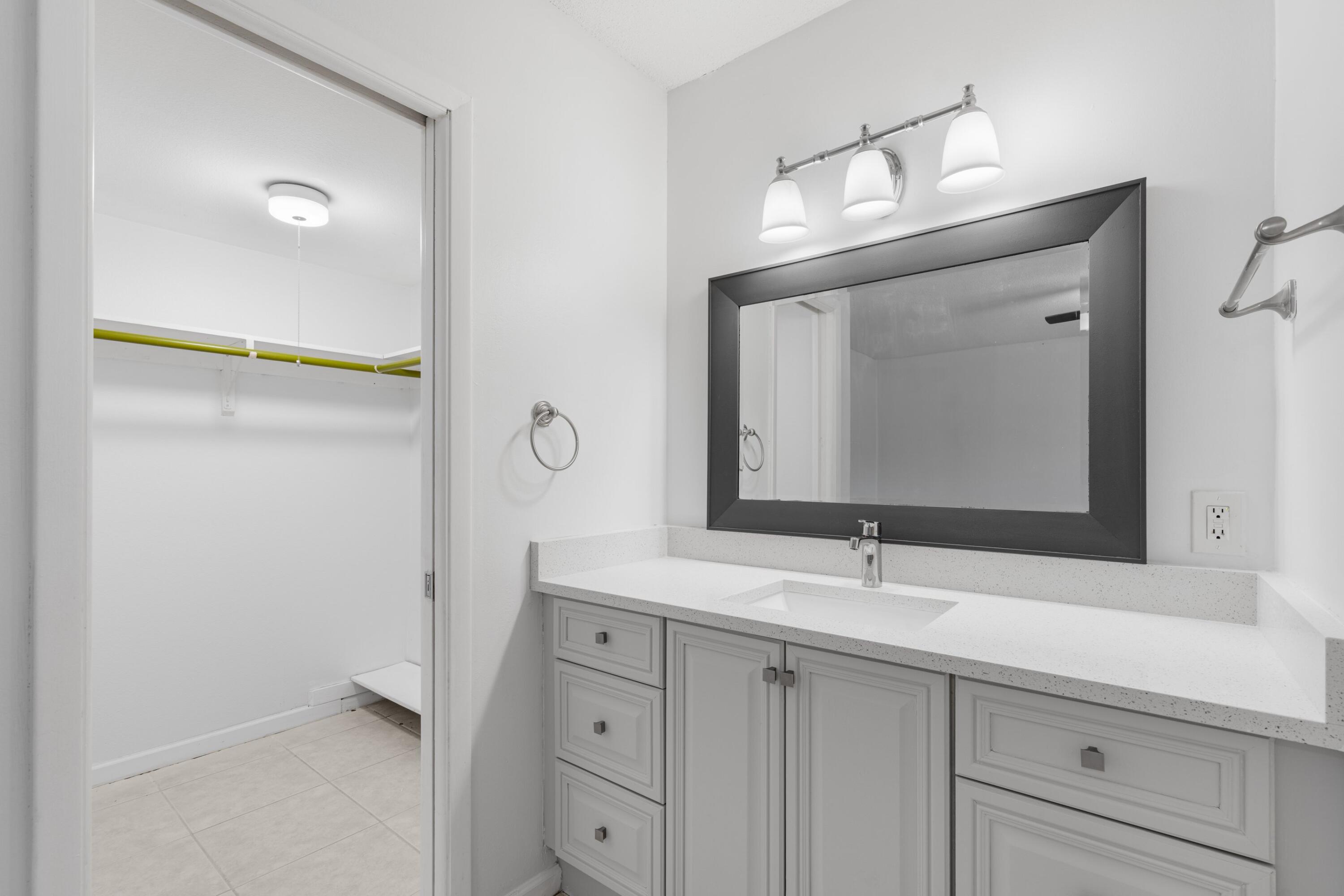 10693 North Military Trail, Unit 7 Palm Beach Gardens, FL 33410 - Photo 17 of 28 a bathroom with a sink vanity and mirror