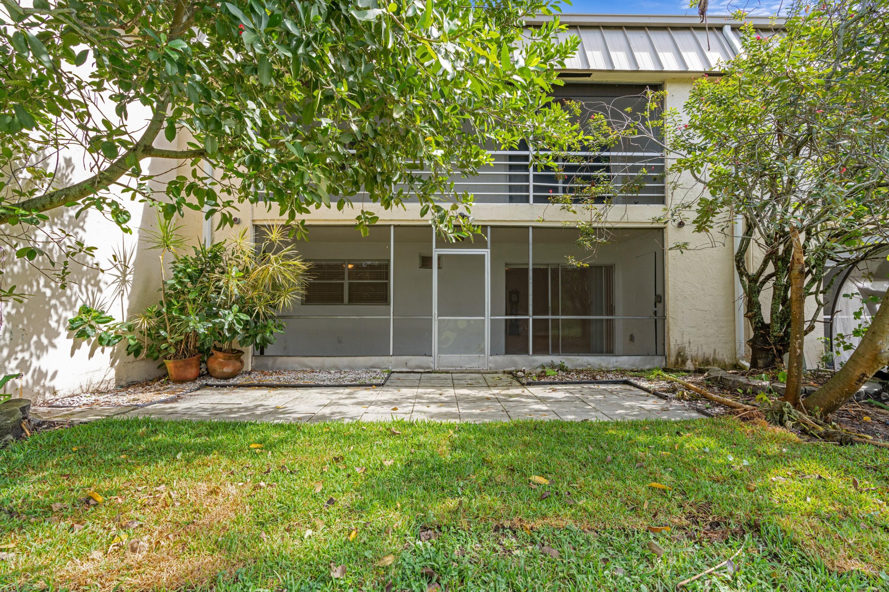 10693 North Military Trail, Unit 7 Palm Beach Gardens, FL 33410 - Photo 25 of 28 a front view of a house with a garden