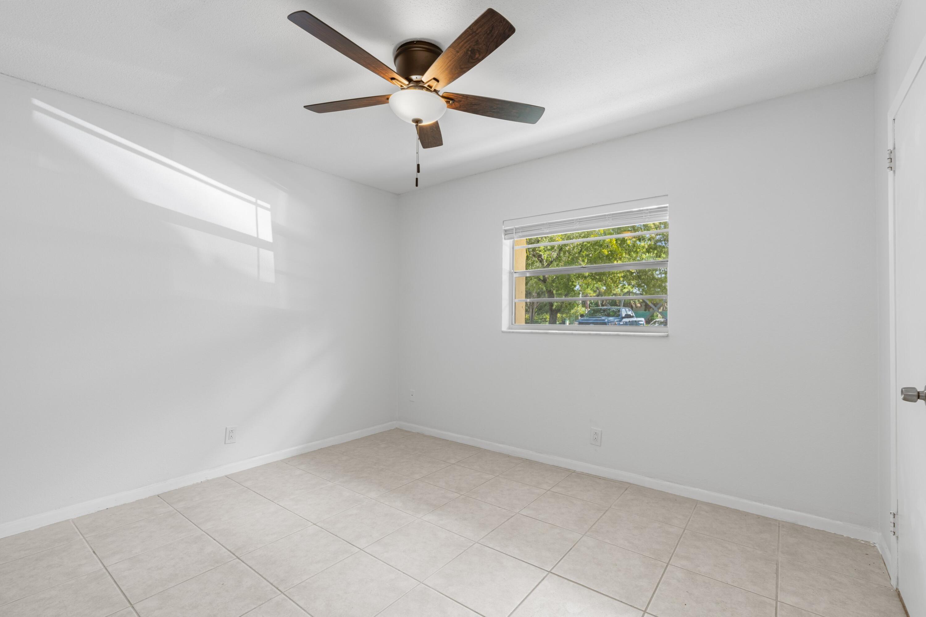 10693 North Military Trail, Unit 7 Palm Beach Gardens, FL 33410 - Photo 7 of 28 an empty room with windows and ceiling fan