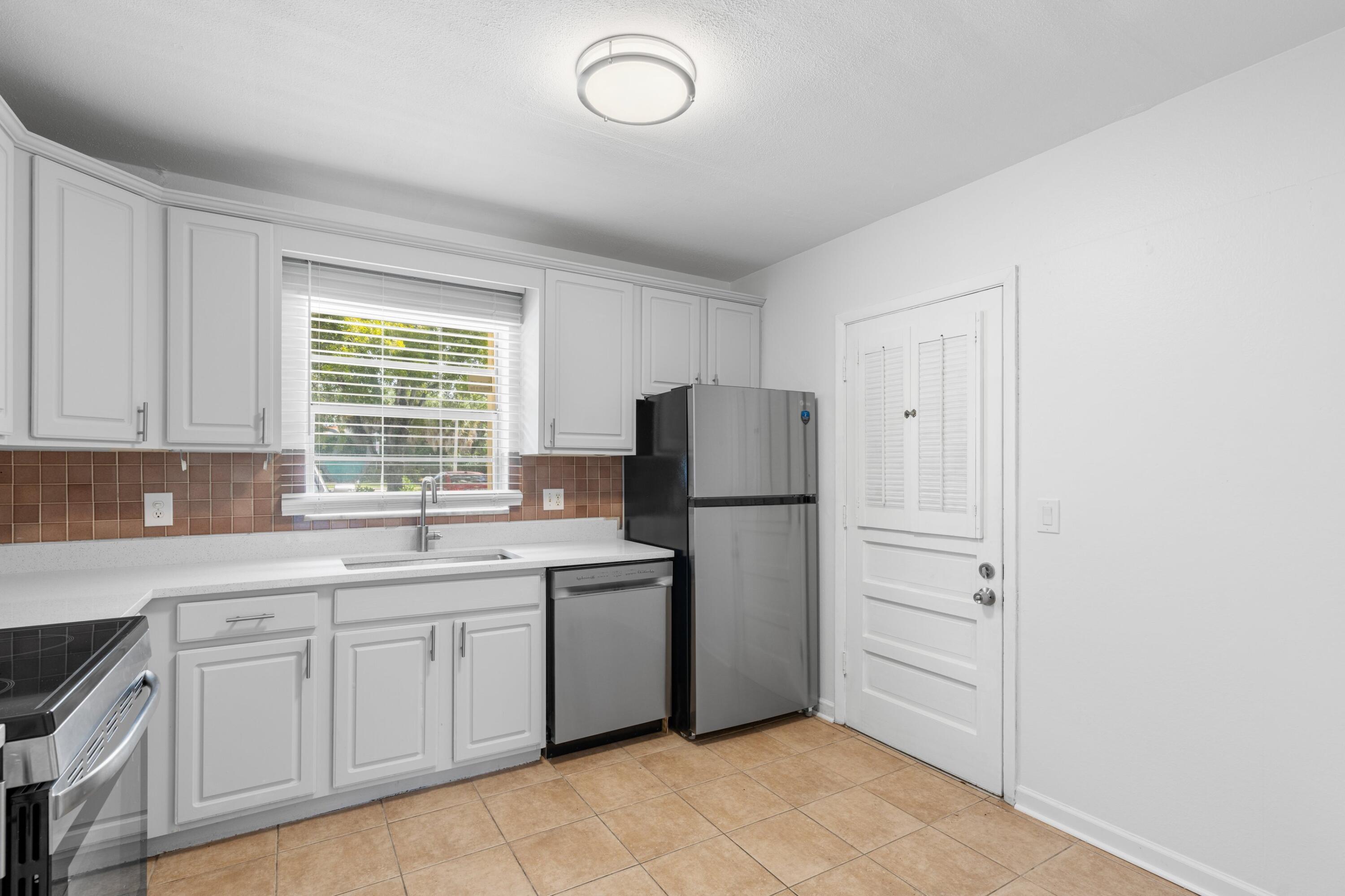 10693 North Military Trail, Unit 7 Palm Beach Gardens, FL 33410 - Photo 10 of 28 a kitchen with a refrigerator sink and cabinets