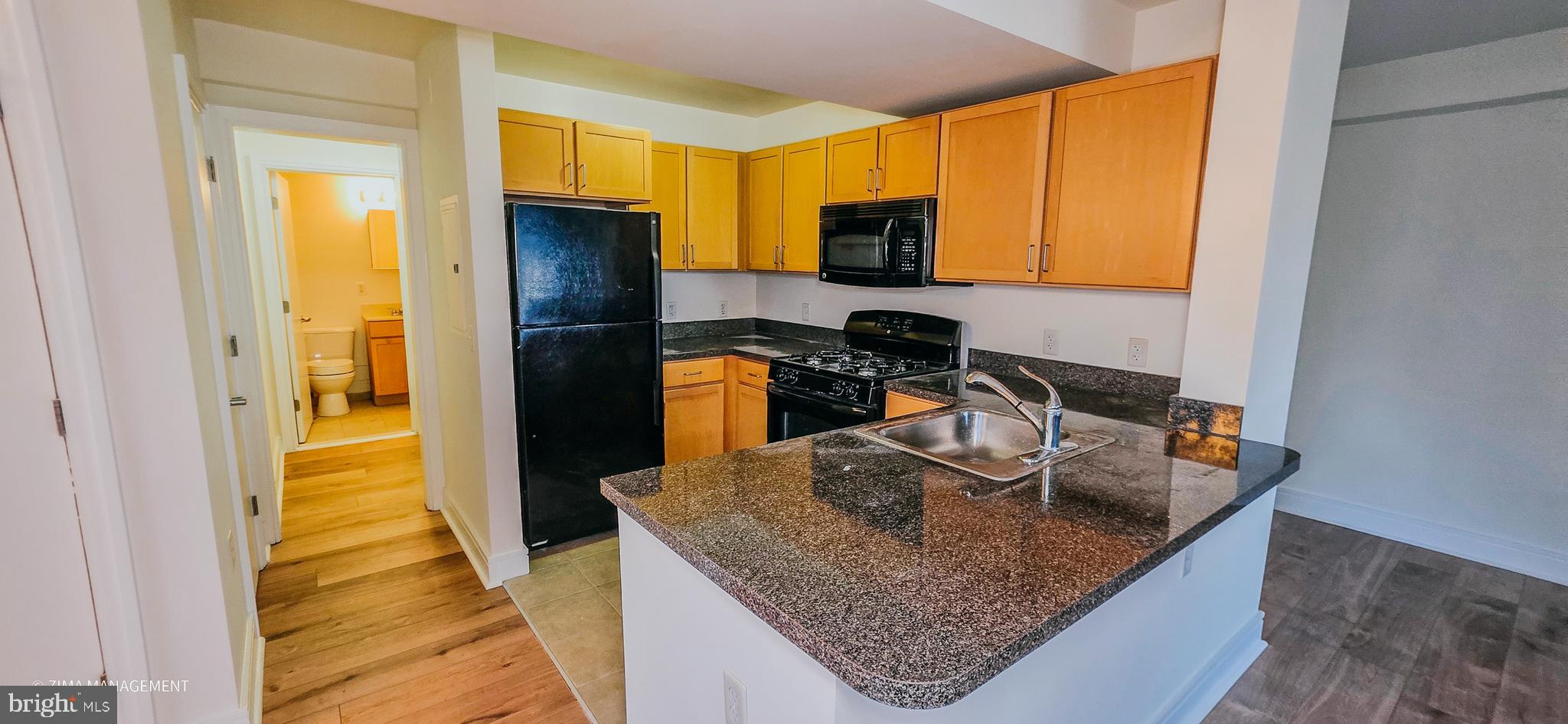 800 4th Street Southwest, Unit S402 Washington, DC 20024 - Photo 11 of 17 a kitchen with kitchen island granite countertop a sink stove and refrigerator