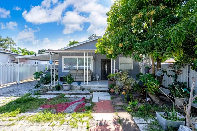 a view of house with backyard and sitting area